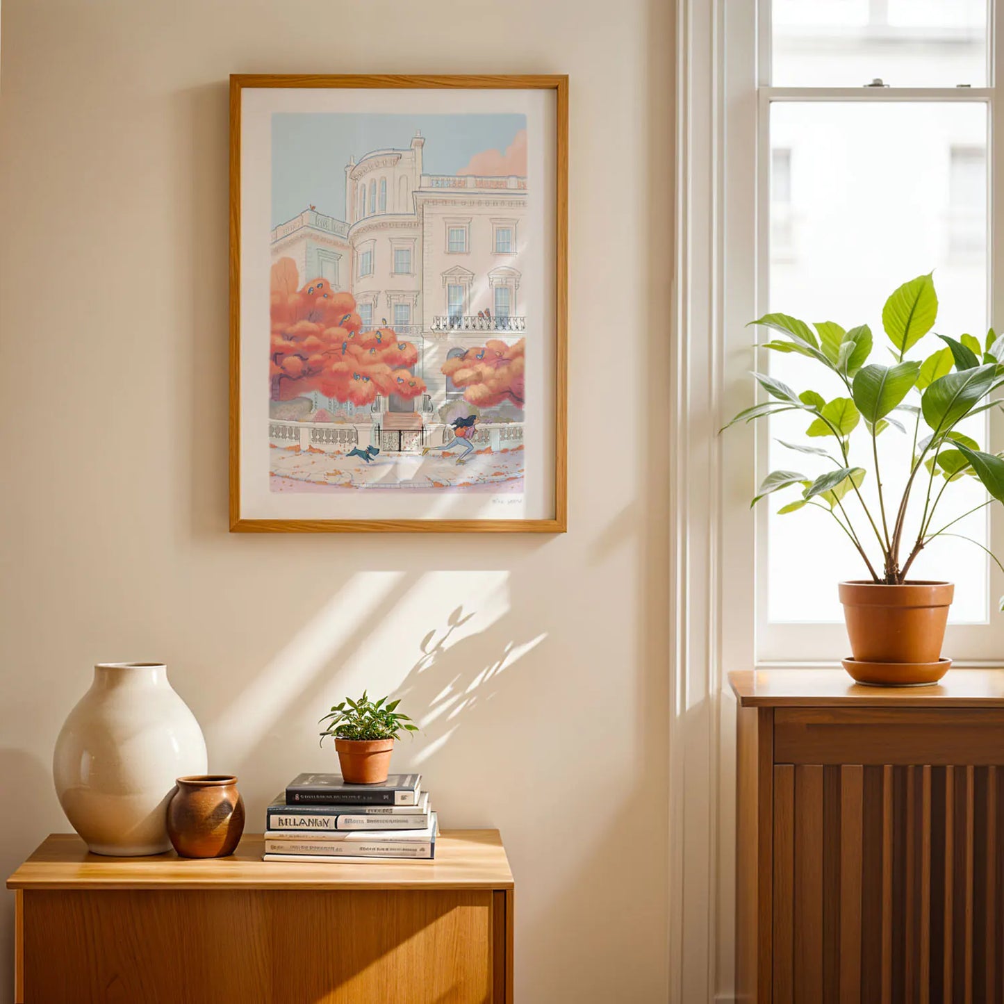 Framed print on a wall of a painting of a lady skating with her dog in the Autumn on a street in London's Notting Hill