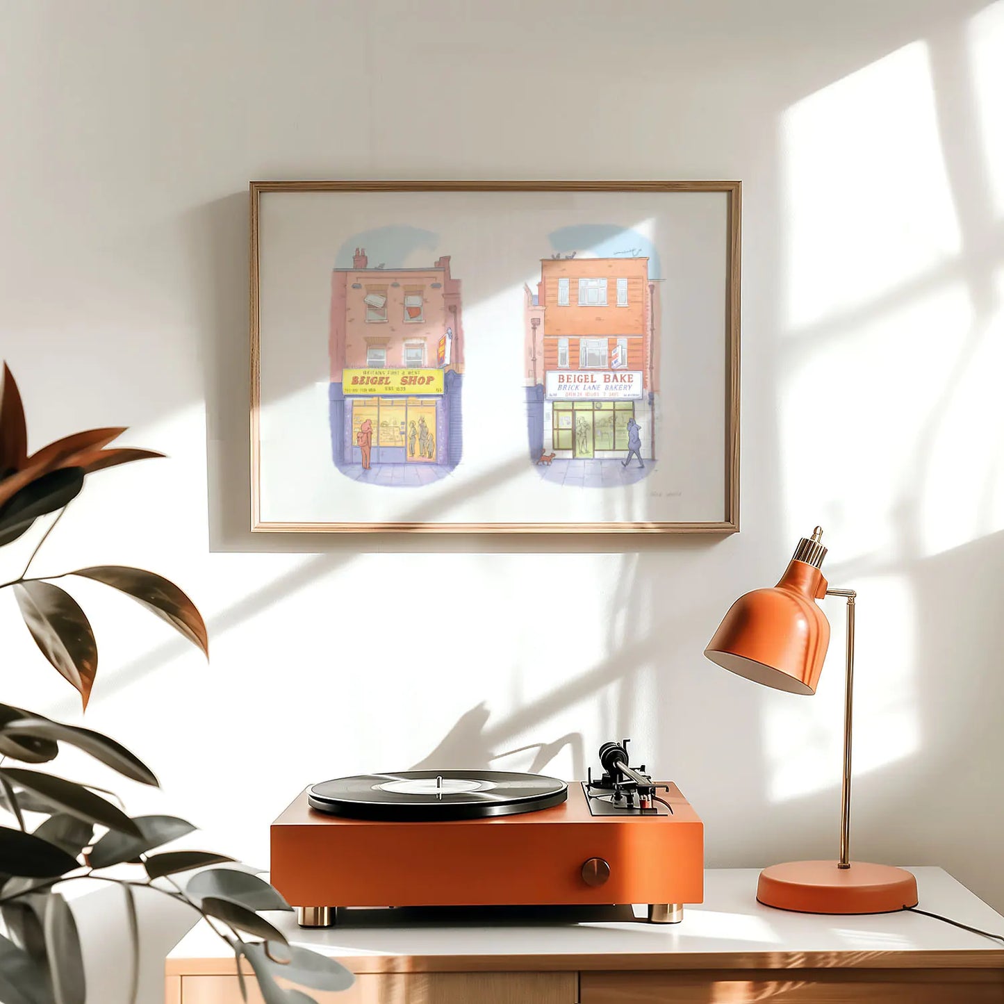 Framed art print of an illustration of the two famous Beigel shops on Brick Lane in London above a record player