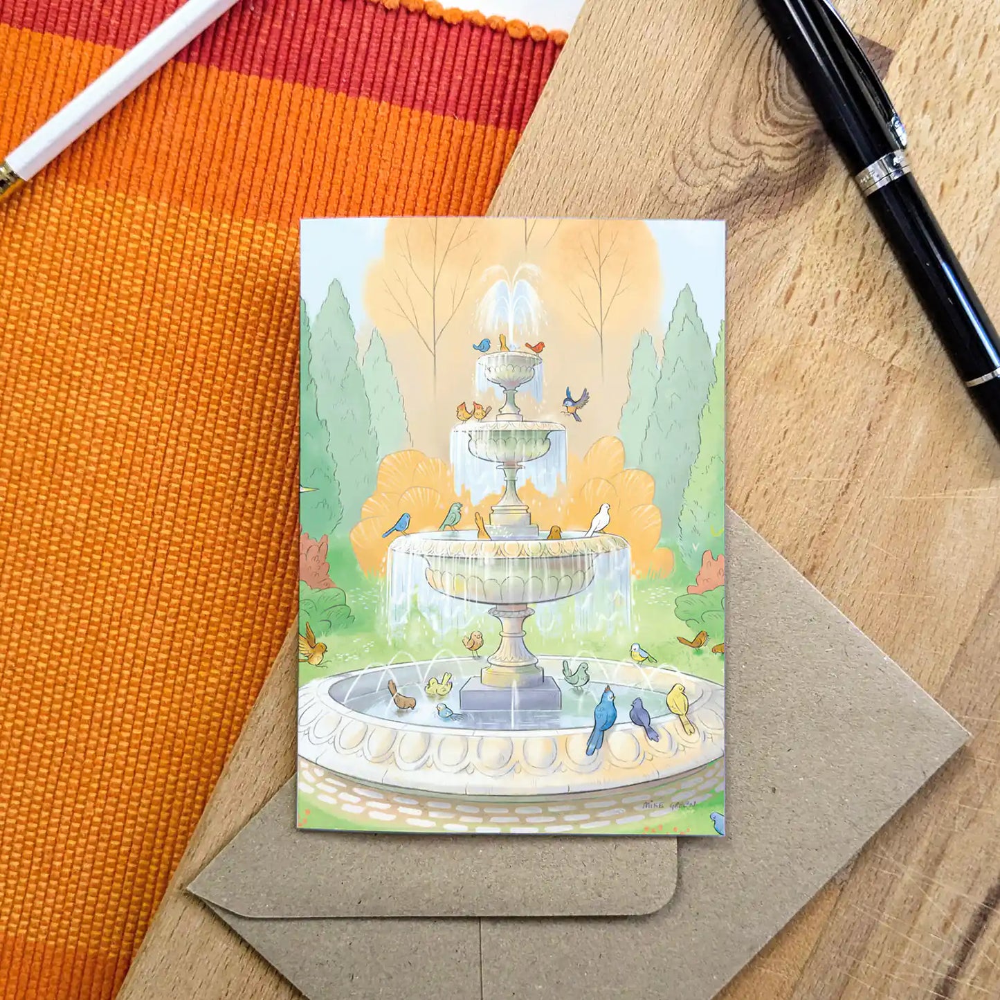 Illustration of colourful birds drinking from a fountain on a greetings card