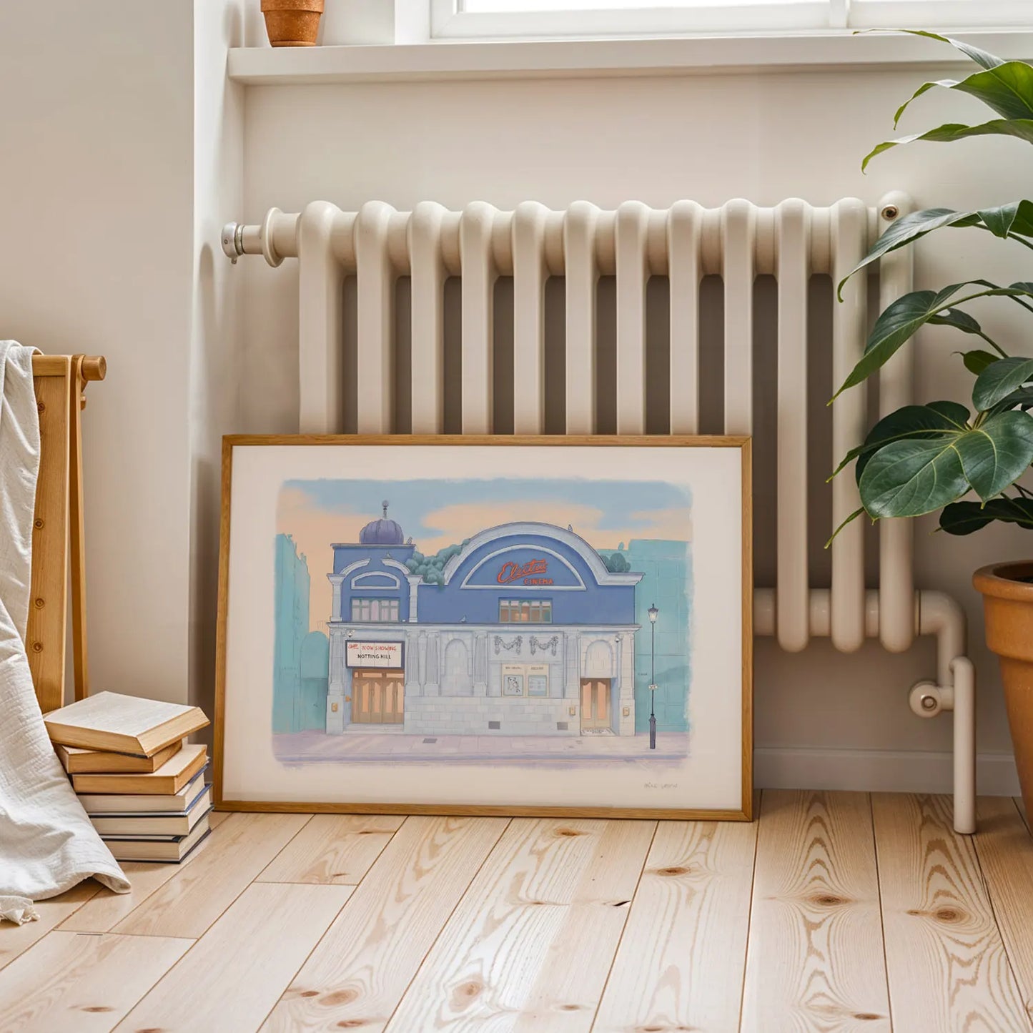 Framed print of The Electric Cinema Notting Hill painted by Mike Green Illustration on floor with plant