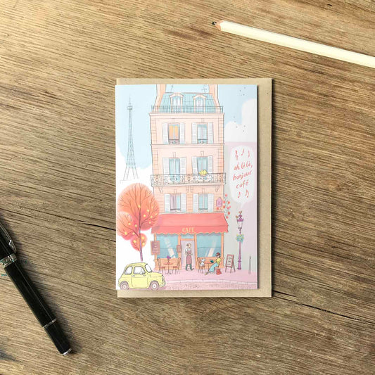 Paris cafe with lady and dog and bonjour cafe text beautifully illustrated on a greeting card by mike green illustration.