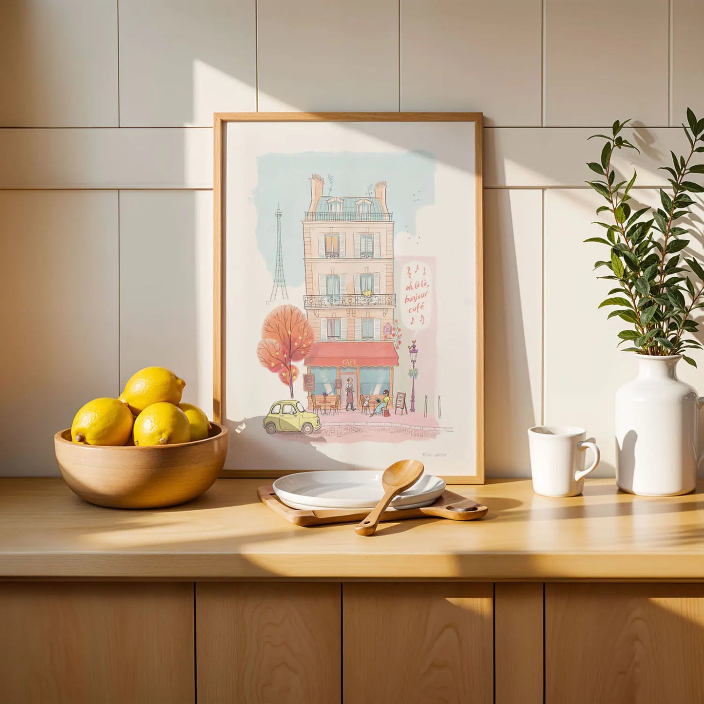 framed print of a Paris cafe with bowl of fruit and plant in white vase