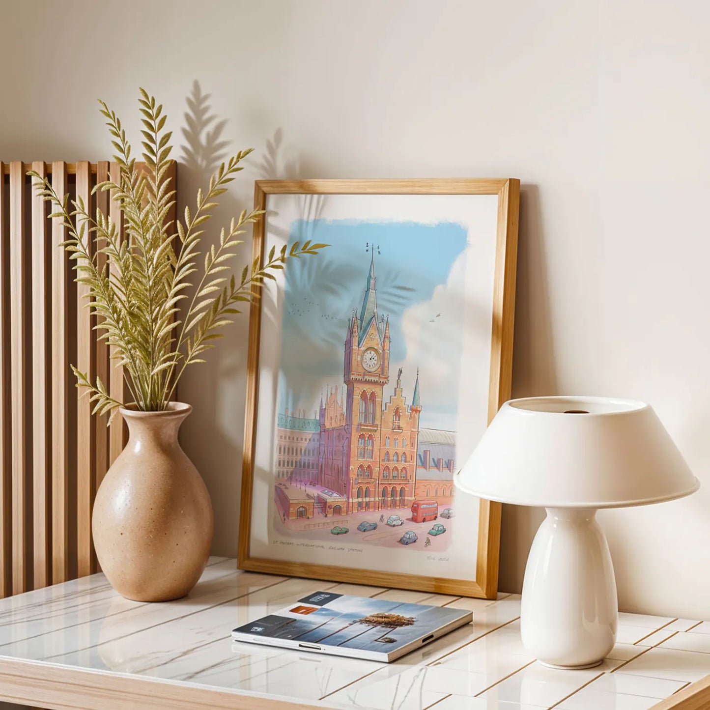 Framed art print of a painting of St Pancras International Railway Station in London by Mike Green Illustration next to a lamp