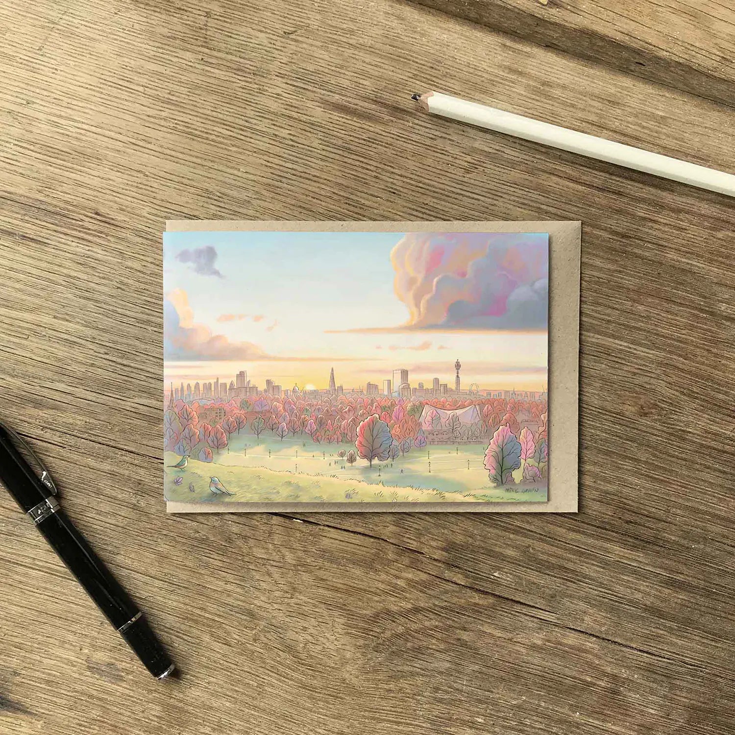 Greetings card with a view from Primrose Hill at sunrise in the Autumn with a pen and pencil and brown envelope