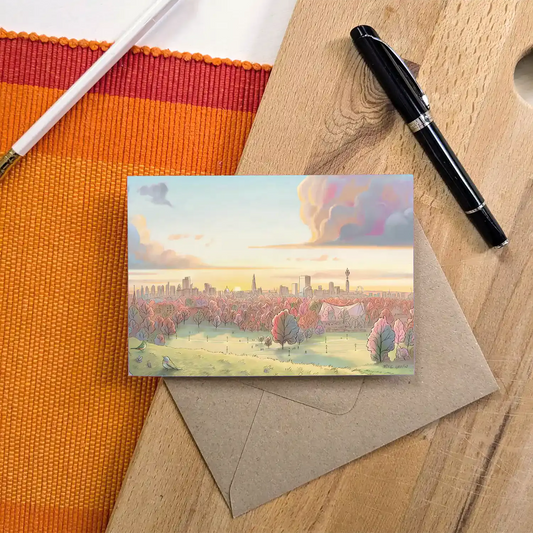 Greetings card with a view from Primrose Hill at sunrise in the Autumn with a pen and pencil and brown envelope