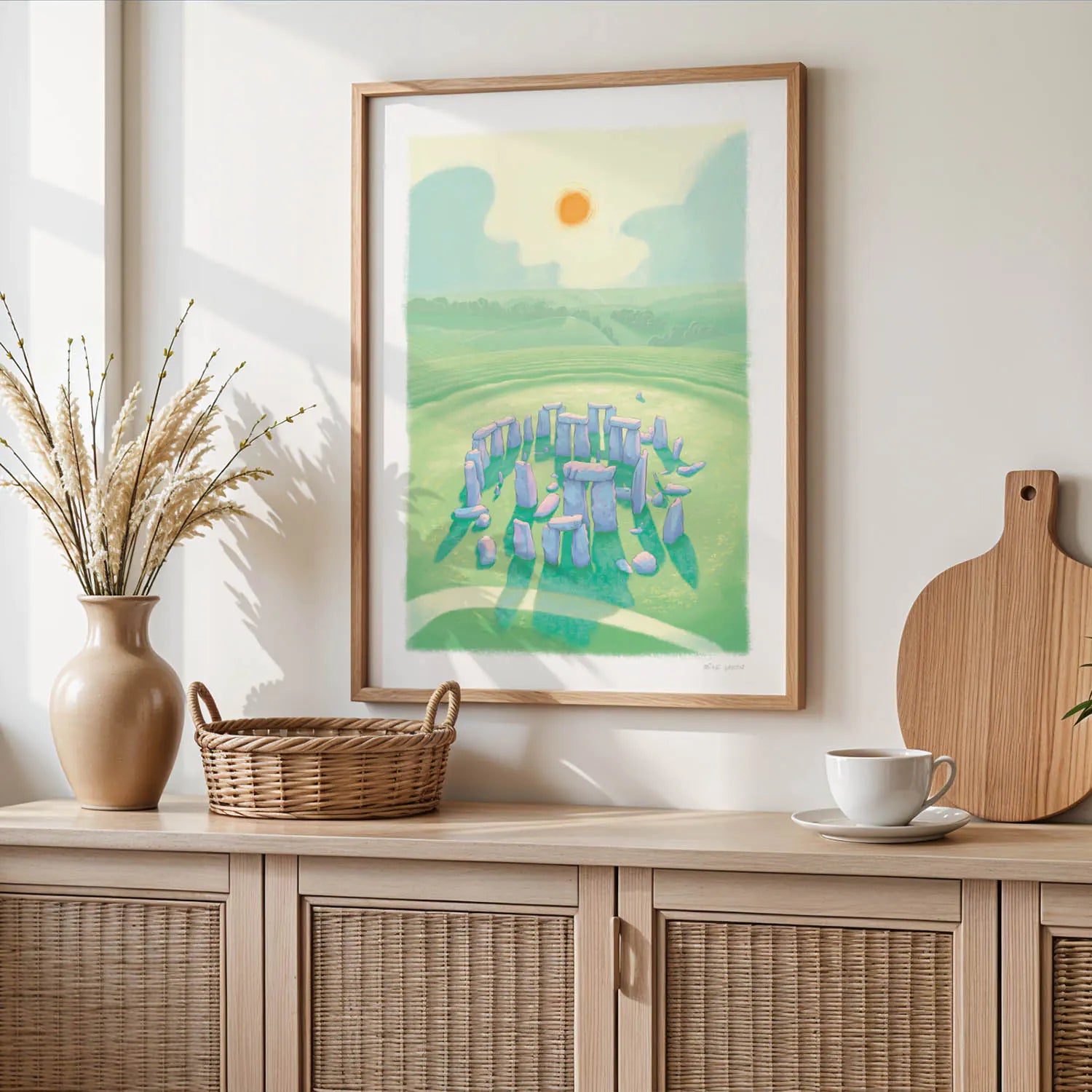 Wall art print of a painting of Stonehenge in Wiltshire England on a wooden shelf with basket and cup