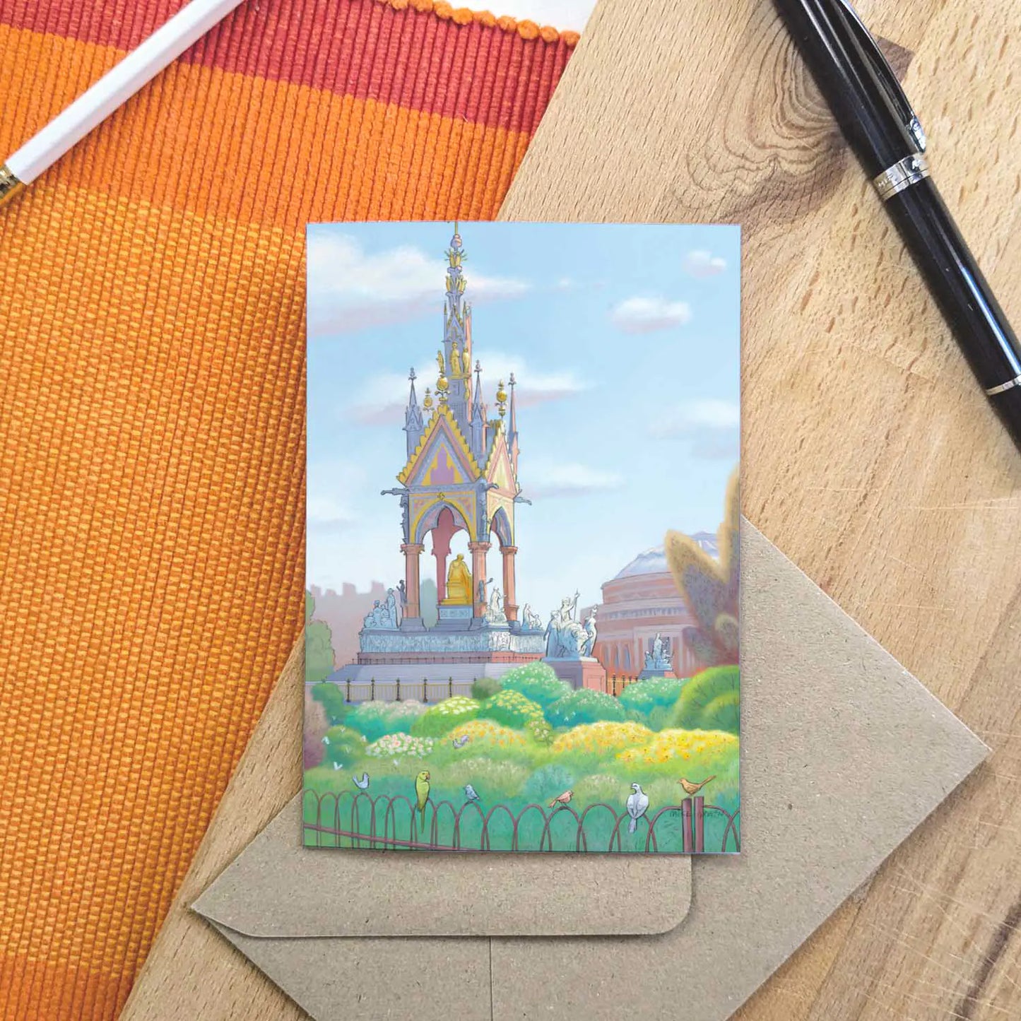 Greetings card with a painting of the Albert Memorial in Kensington Gardens on  board with a pen and envelope