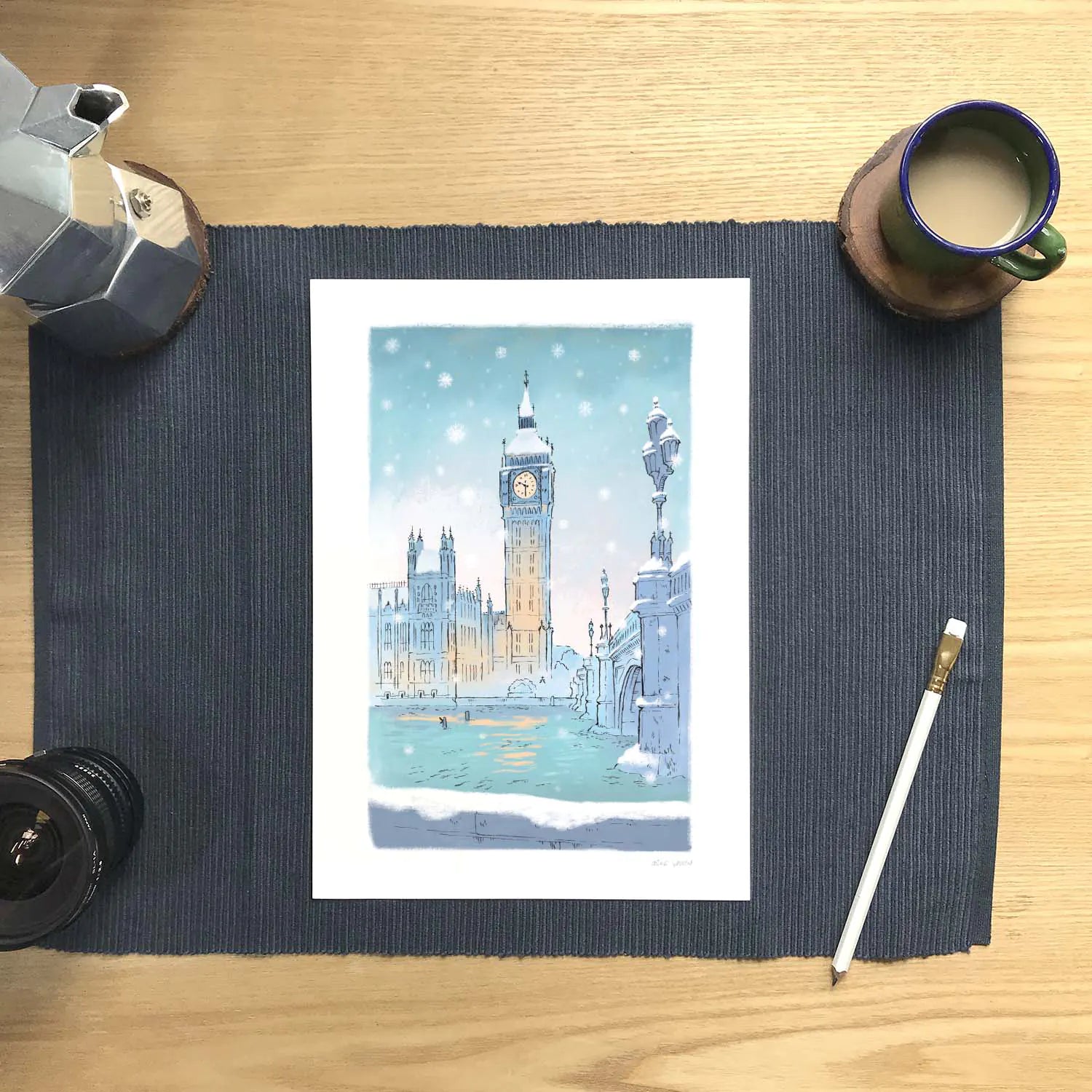 London's big ben in the snow wall art print with a coffee and pencil on a desk