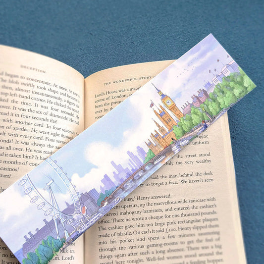 A bookmark with a painting of Big Ben and the London Eye resting on an open book