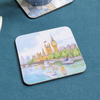 A square coaster with rounded corners featuring a watercolor-style painting of Big Ben and Westminster Palace in London by the Thames, placed on a textured teal surface.