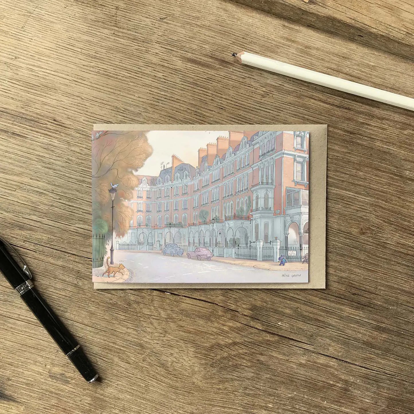 Greetings card with a dog spotting a cat on a west London street in Kensington and Chelsea with a pen and envelope