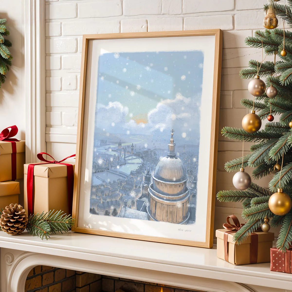 Framed wall art print of St Paul's Cathedral and London skyline in the evening with falling snow on a shelf with Christmas decorations
