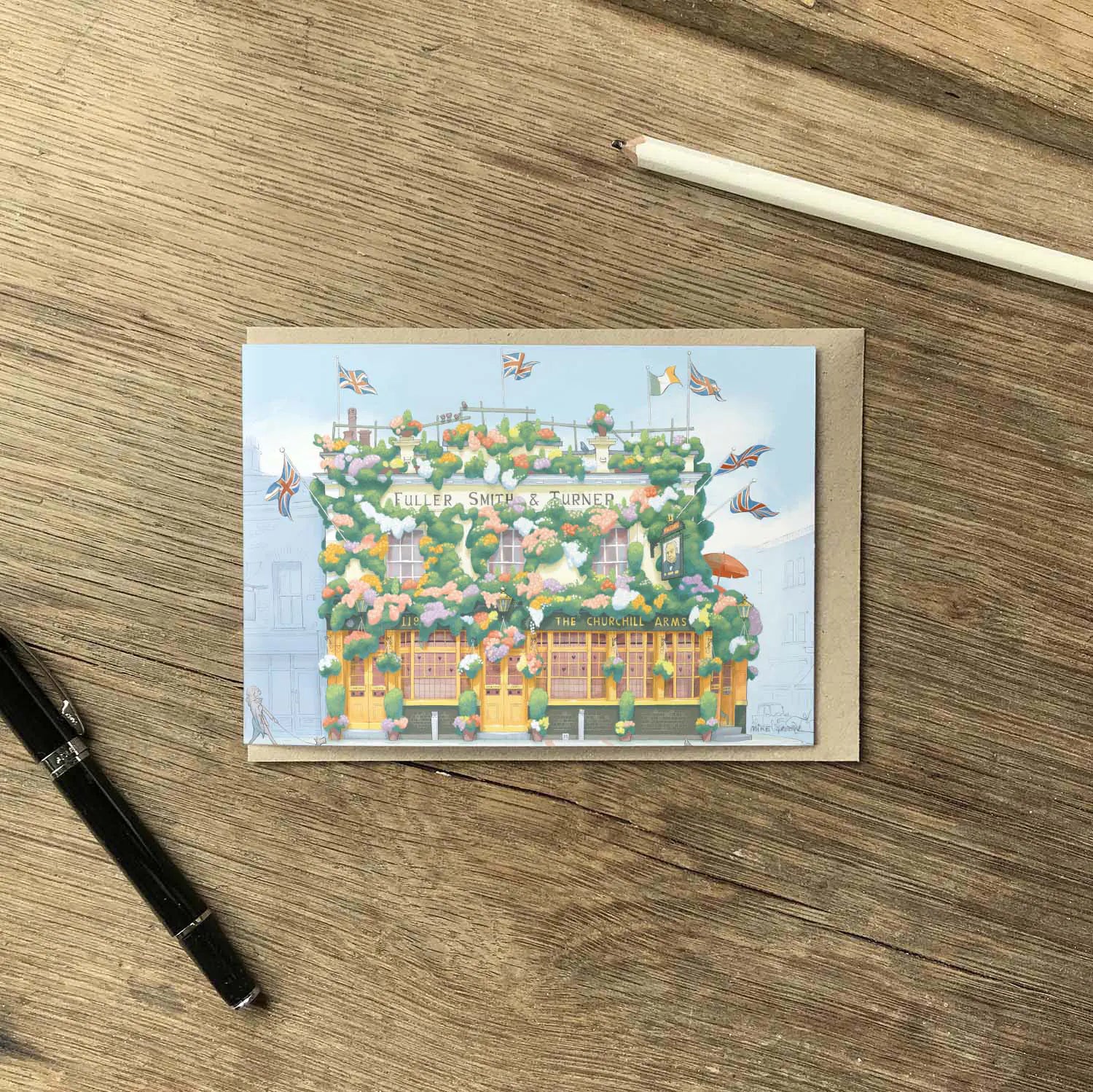 Greetings card of a painting of The Churchill Arms pub in west London's Kensington near Notting Hill with a pen and pencil