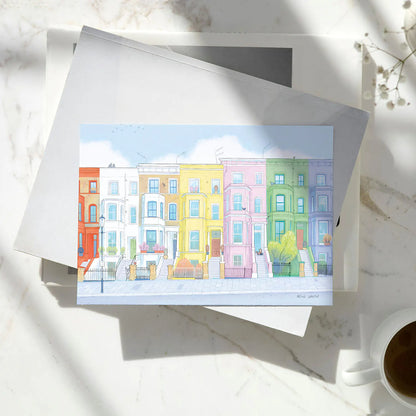 Colourful greetings card with houses from London's Notting Hill on a pile of books