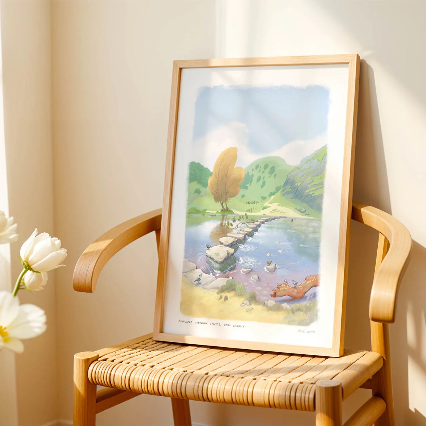 Wall art print of a painting of the stepping stones in Dovedale in the Peak District national park on a chair in the sunshine