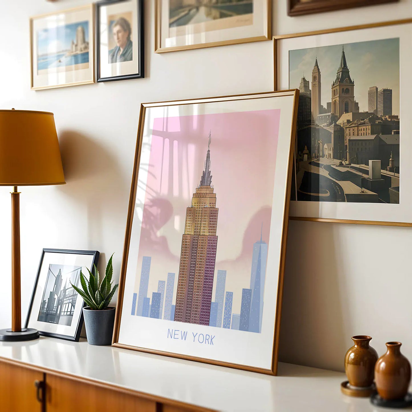 Framed art print of New York's Empire State Building landmark above table with wine