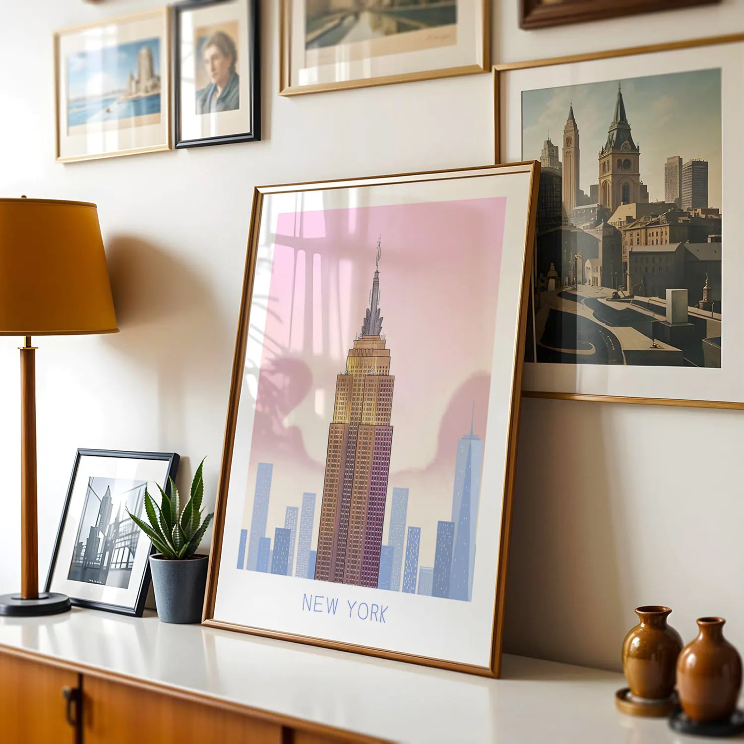 Framed art print of New York's Empire State Building landmark above table with wine
