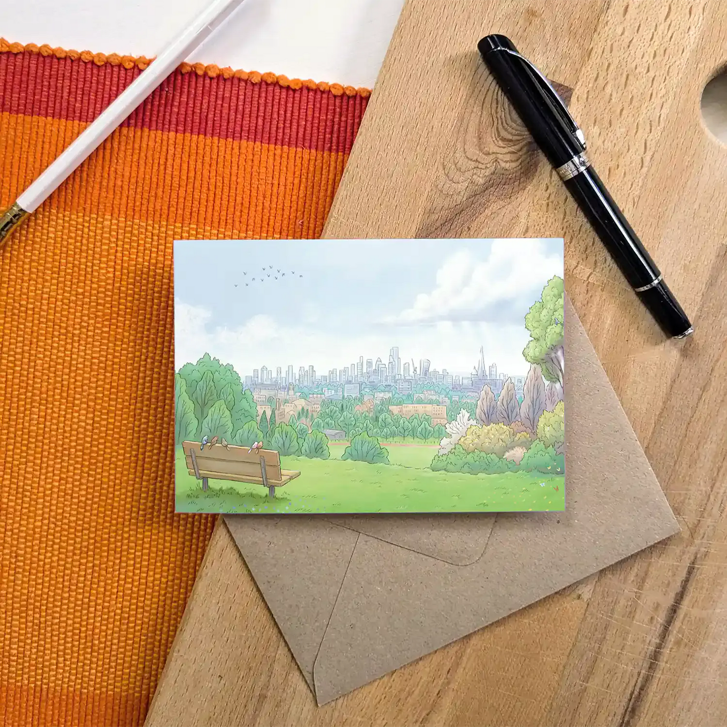 Greetings card with a painting of the view from London's Parliament Hill in Hampstead Heath with an envelope and pen