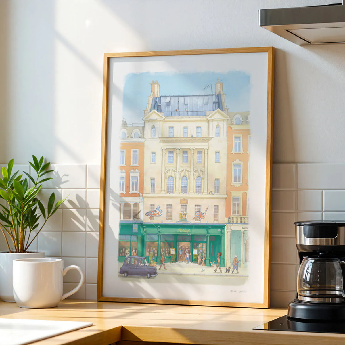 A wall art print of Hatchards bookshop in Piccadilly London in an illustration water colour style, displayed in a kitchen next to a coffee filter