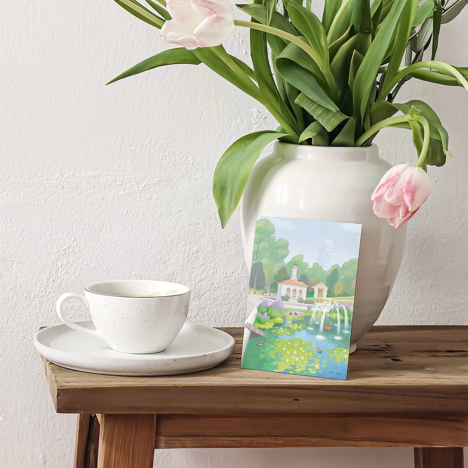 Greetings card with painting of  the Italian Gardens in London's Hyde Park sitting on wooden table with flowers and coffee cup