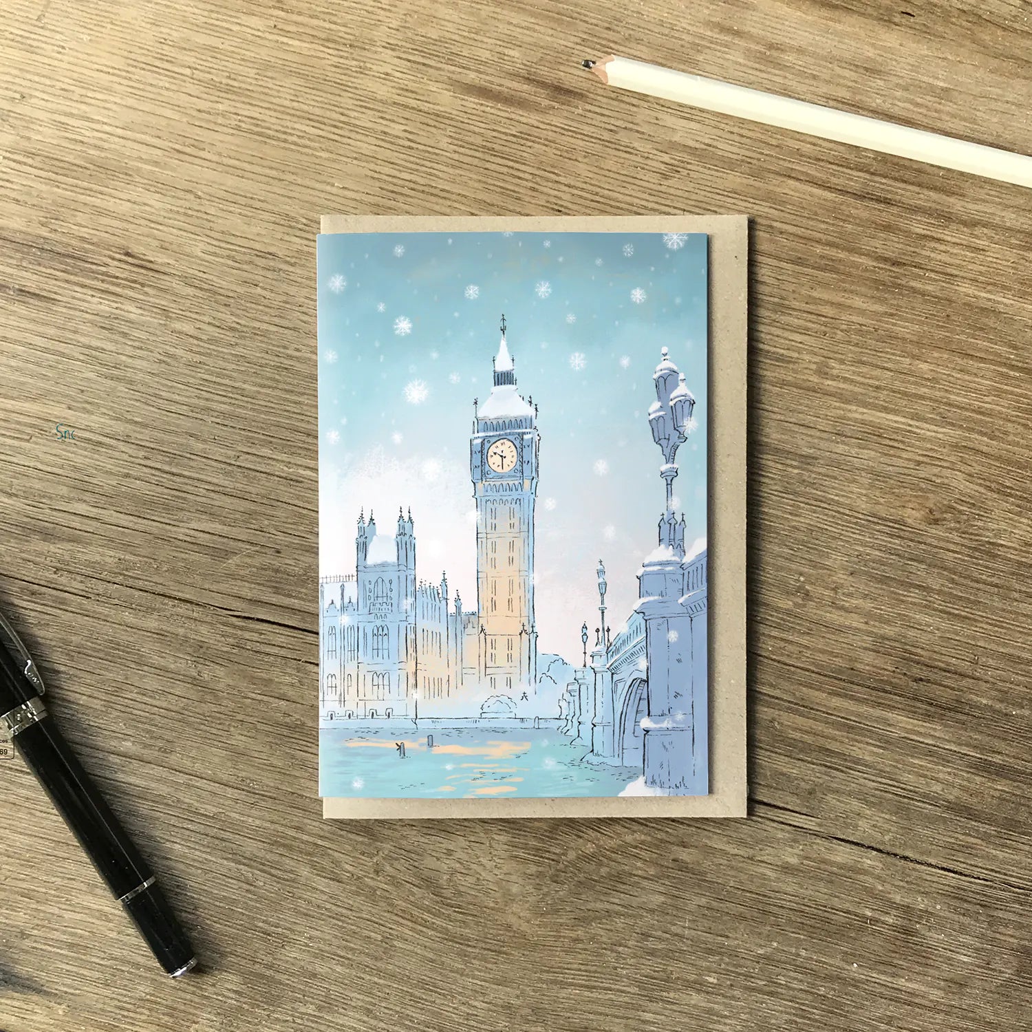 Greetings card with London's Big Ben in the snow in Westminster with a pen and envelope