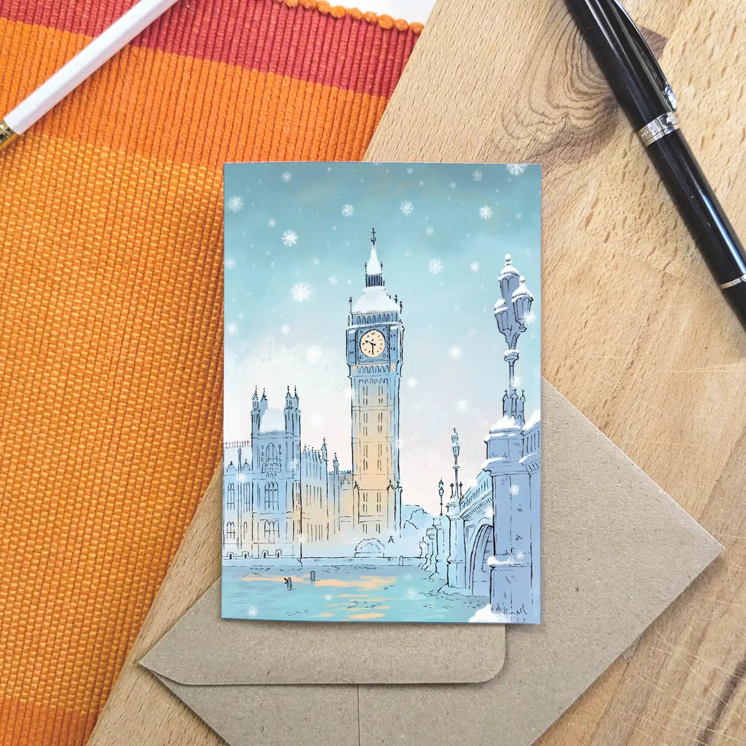Greetings card with London's Big Ben in the snow in Westminster with a pen and envelope