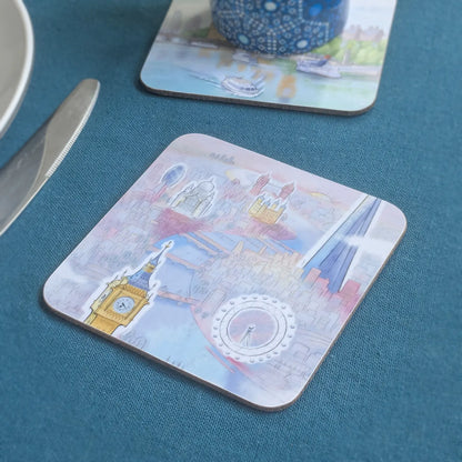 Square cork drinks coaster with rounded corners of London skyline in pastel shades on a table cloth with coaster in background