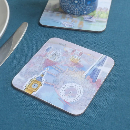 Square cork drinks coaster with rounded corners of London skyline in pastel shades on a table cloth with coaster in background