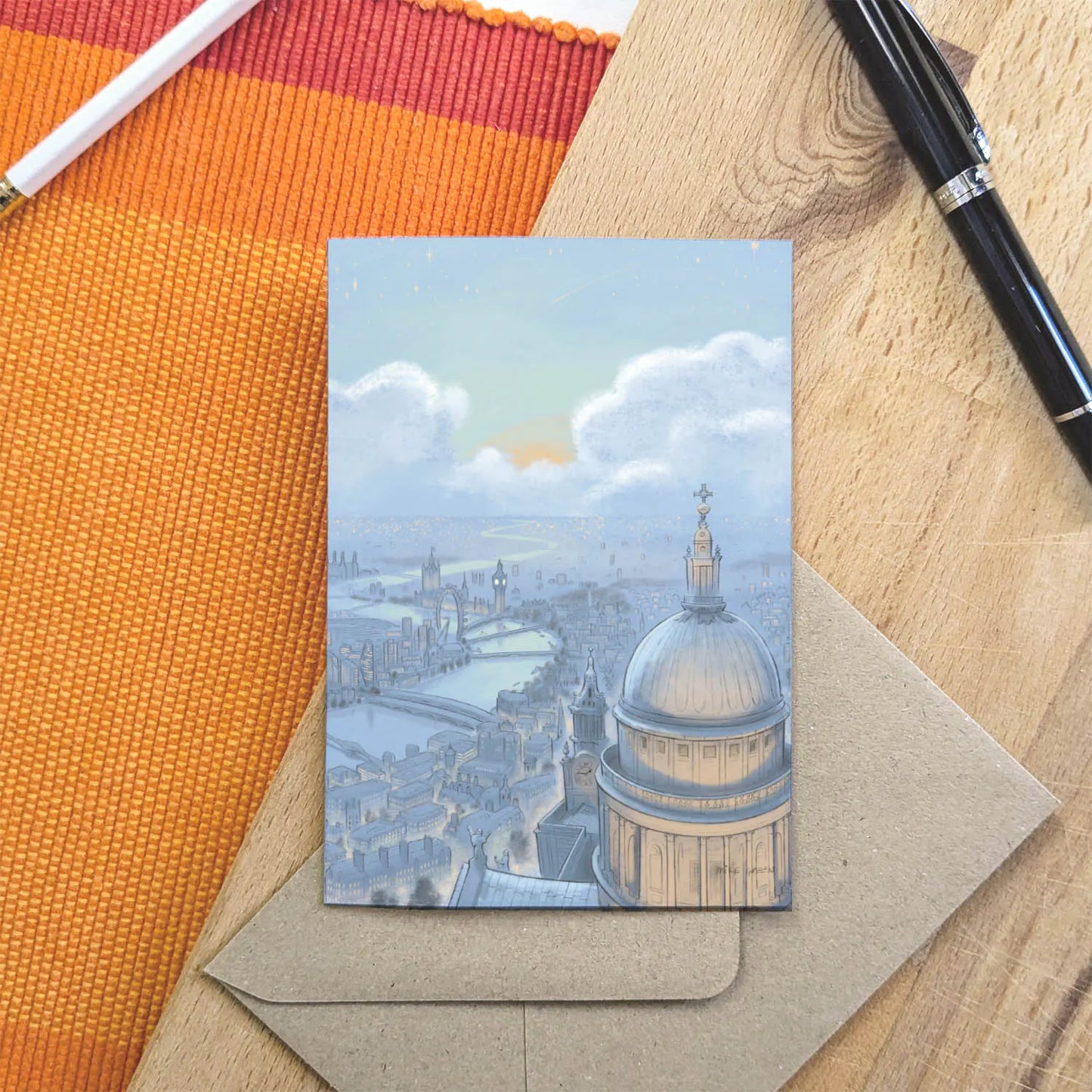 Greetings card with painting of London skyline at night with St Pauls Cathedral and Big Ben with a pen and envelope