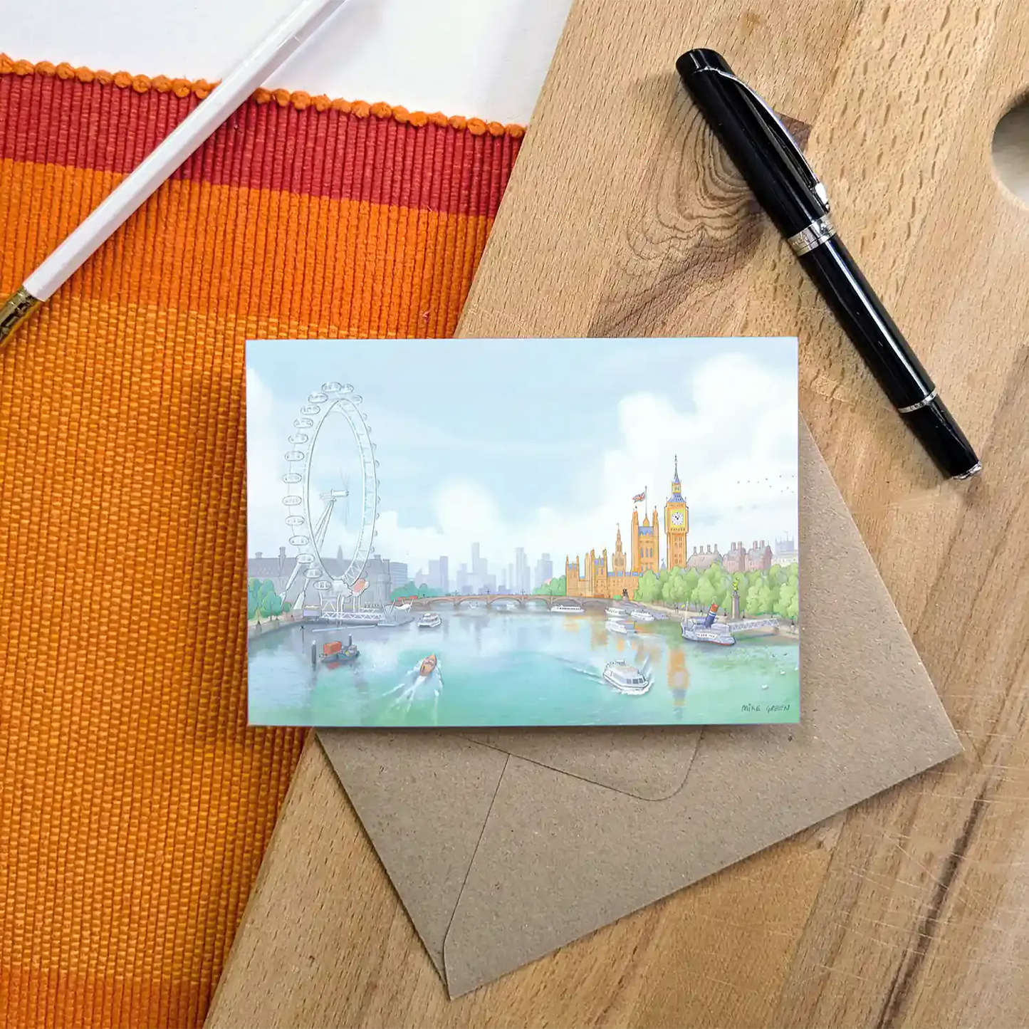 Greetings card with an illustration of the view south from London's Golden Jubilee Bridge with Houses of Parliament and the London eye with an envelope and pen