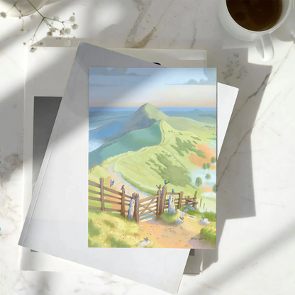 Greetings card with a painting of the Mam Tor ridge way path in the Peak District National Park in England on a pile of books