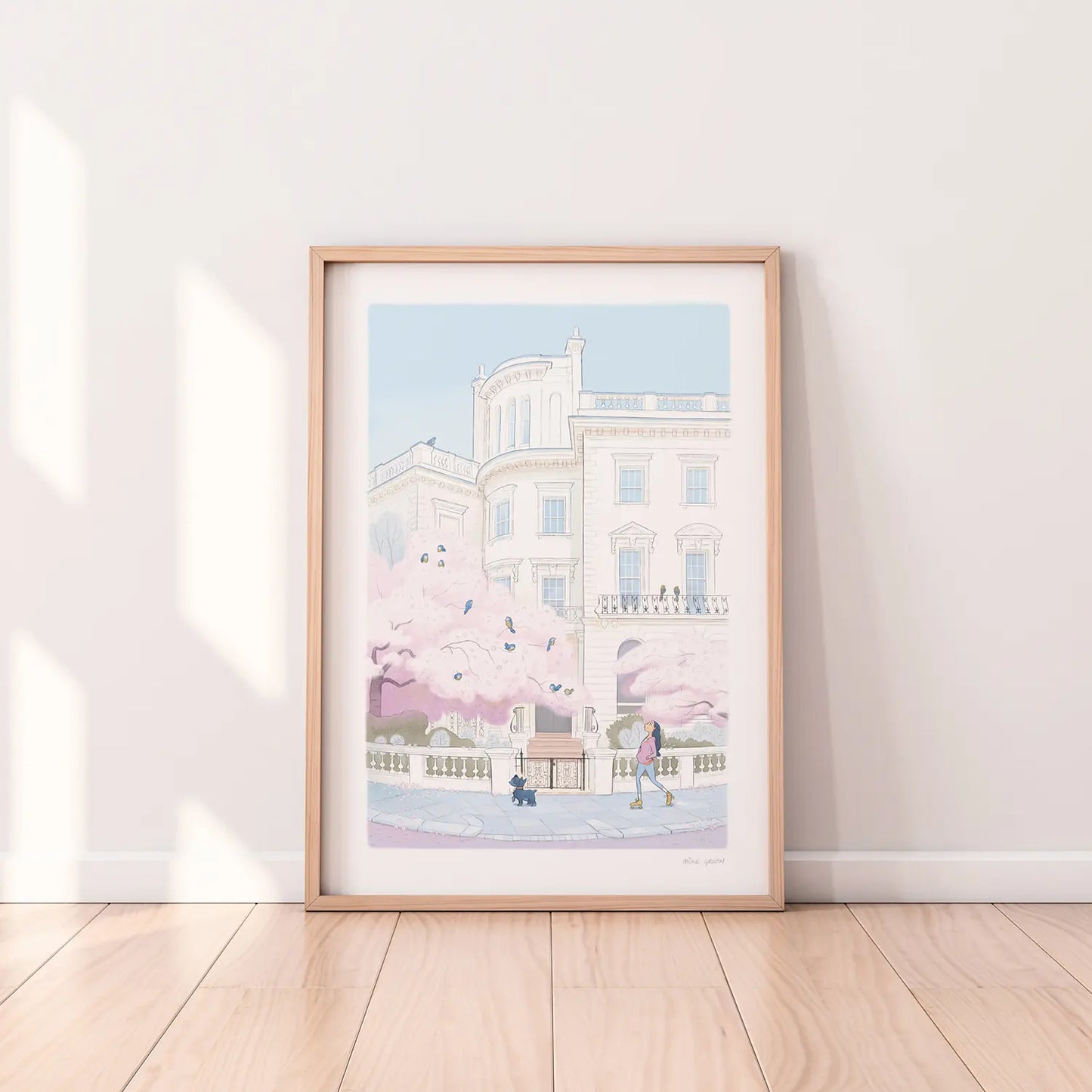 Framed print of a painting of a lady skating with her dog on a street in London's Notting Hill with a tree in blossom