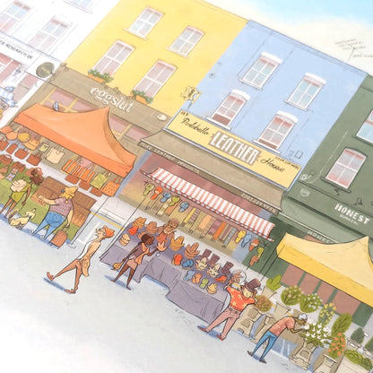 Wall art print of a pastel watercolor illustration of Portobello Road Market in London's Notting Hill with colorful buildings, storefronts, pedestrians, and market stalls.