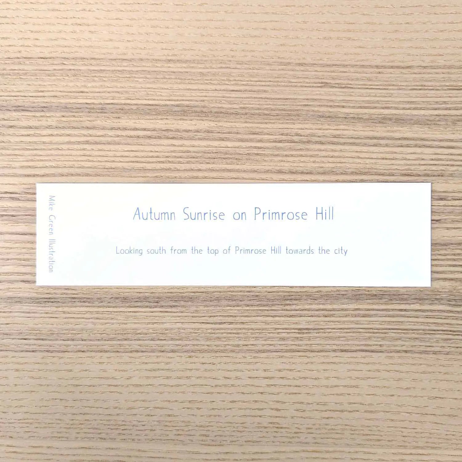 Back of a bookmark of the view from London's Primrose Hill on a wooden surface