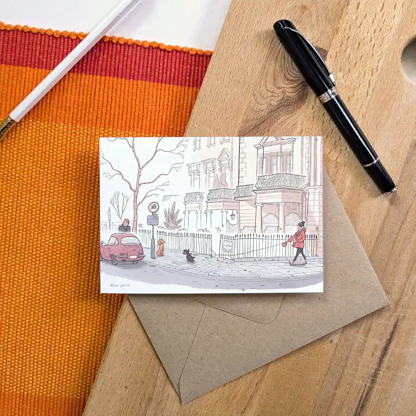 Dog walkers on a street in London's Kensington street beautifully illustrated on a greeting card by mike green illustration.