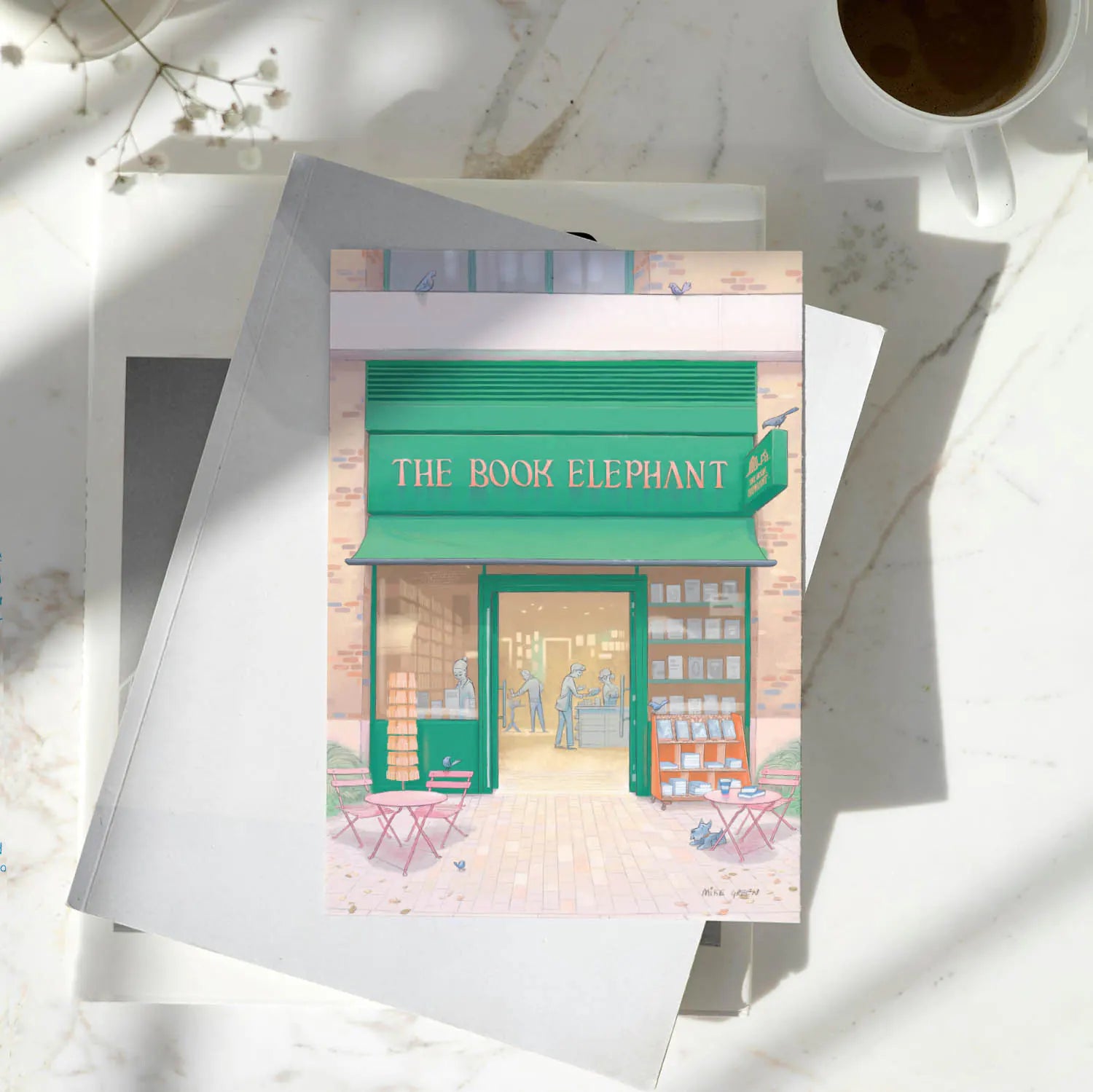 Greetings card of The Book Elephant book shop in Elephant and Castle south London on a pile of books on a table