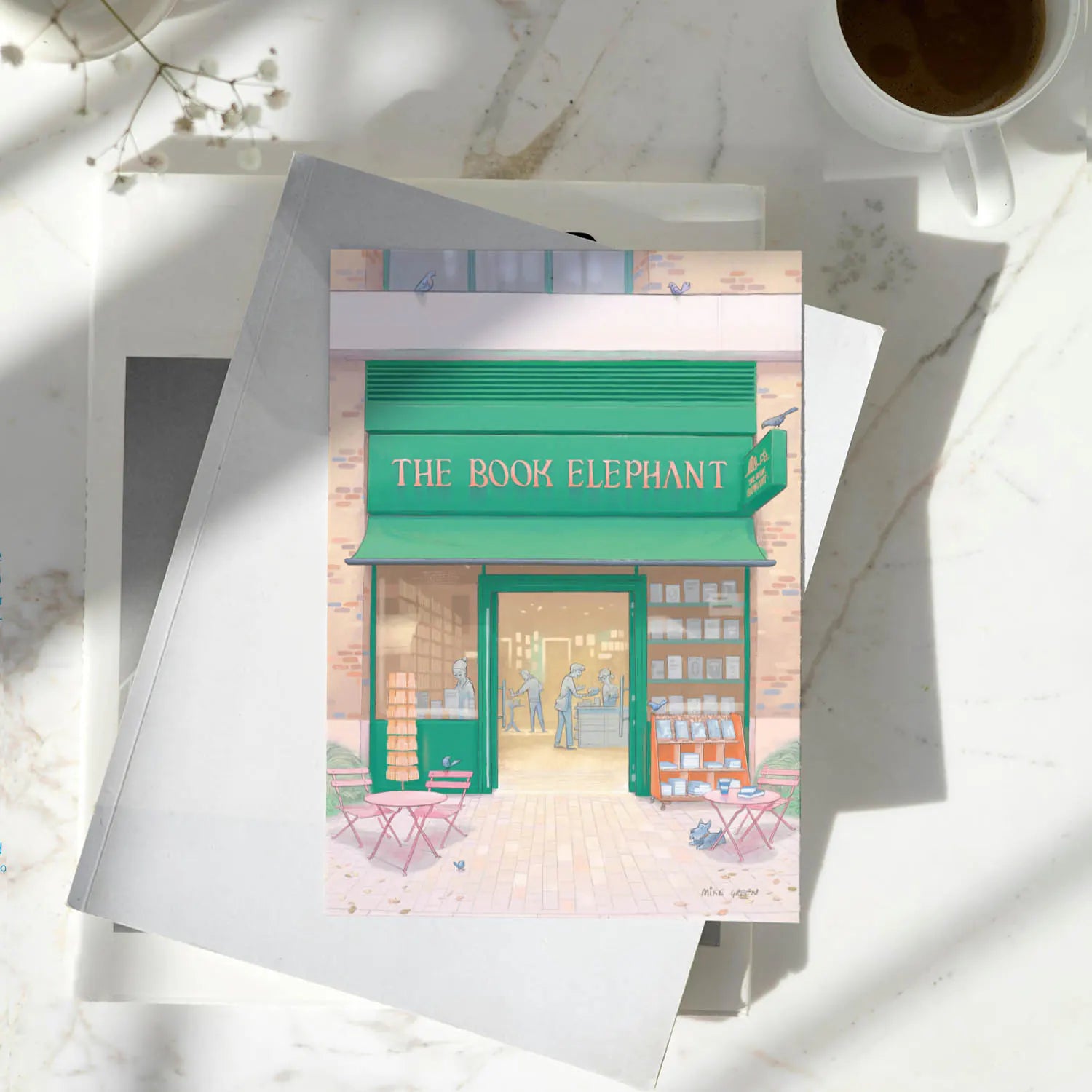 Greetings card of The Book Elephant book shop in Elephant and Castle south London on a pile of books on a table