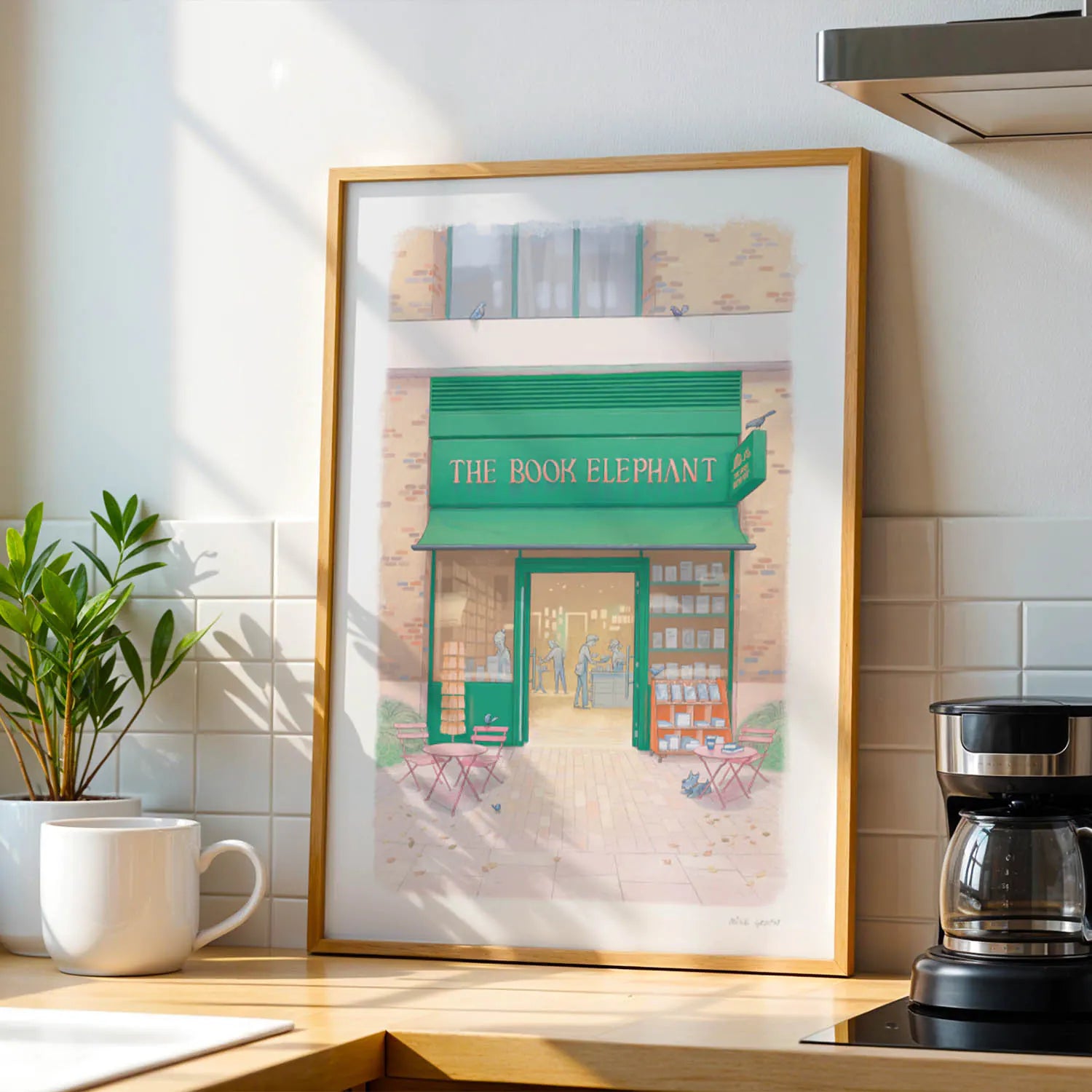 Wall art print The Book Elephant shop in on a kitchen side with coffee and cup