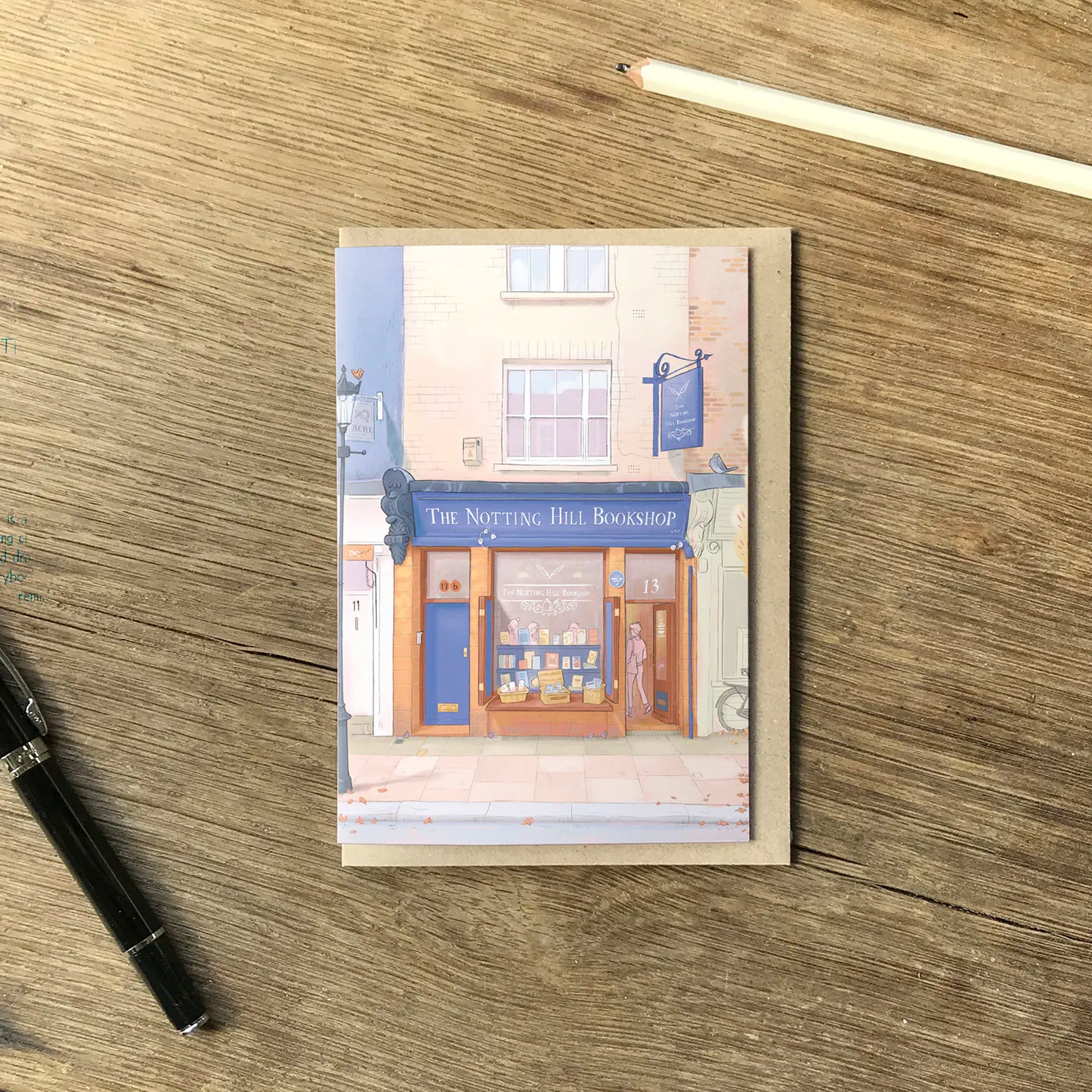 Greetings card with an illustration of London's The Notting Hill Bookshop in the Autumn with a pencil