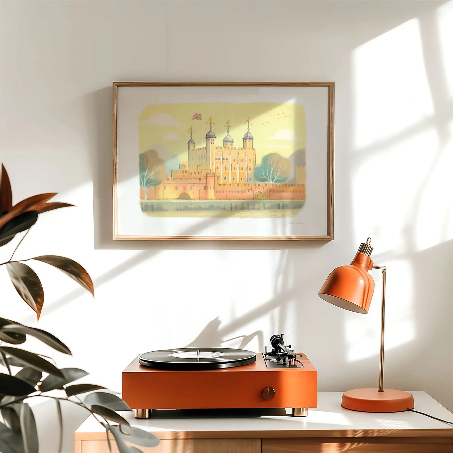 A framed art print of the Tower of London castle above a lamp and record player