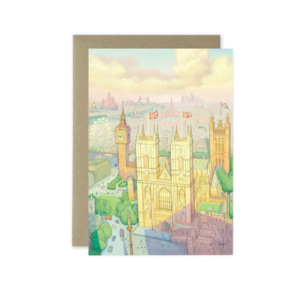 A greetings card featuring a pastel illustration of London landmarks, including Big Ben, Westminster Abbey, and the London Eye, shown with a brown kraft envelope behind it on a white background.