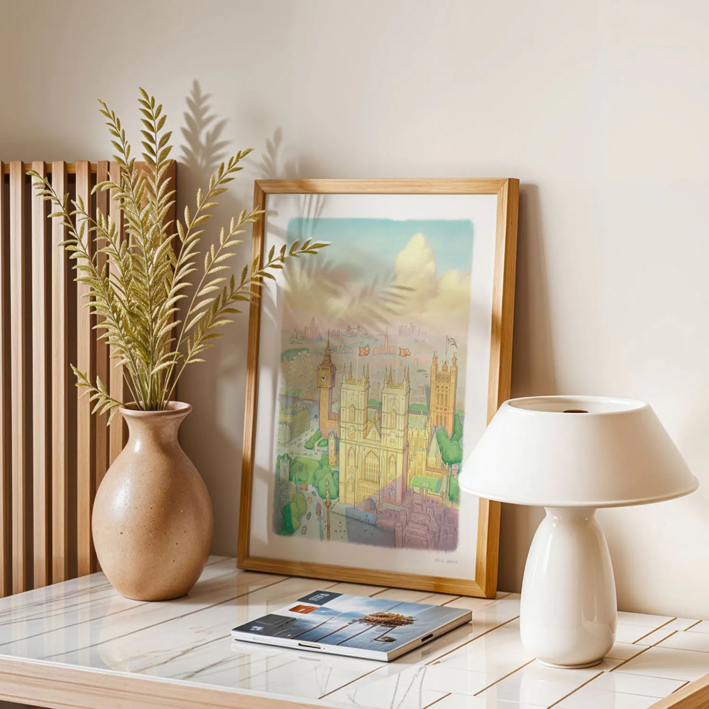 A wall art print of Westminster Abbey in a watercolour illustration style with big ben and the London Eye also shown framed in a room with a window and plants